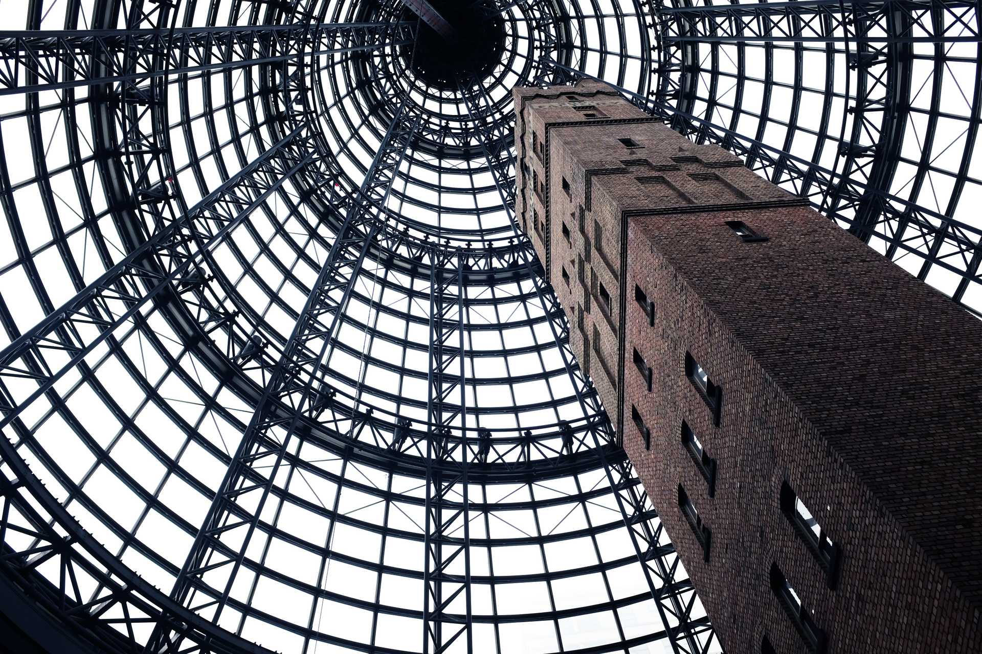 A brick tower in Melbourne, Australia grows beneath a metal frame.