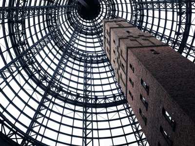 A brick tower in Melbourne, Australia grows beneath a metal frame.